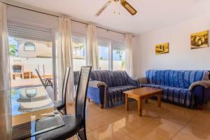 un soggiorno con un divano e un tavolo di Acogedor Chalet con piscina 2ª Línea del Mar Menor a Cartagena