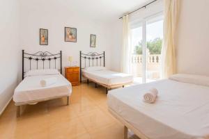 una camera da letto con due letti e una finestra di Acogedor Chalet con piscina 2ª Línea del Mar Menor a Cartagena Altre 43 foto