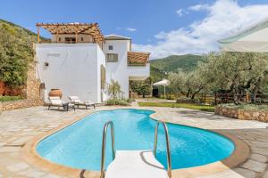 a villa with a swimming pool and a house at Kohili Villas in Skopelos Town