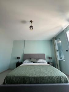 a bedroom with a large bed with a ceiling at Plomari Grey house Casa Peppe in Plomarion
