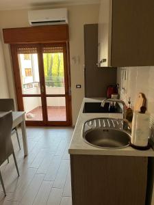 スカレアにあるApartment in Scaleaのキッチン(シンク付)、パティオへのドア
