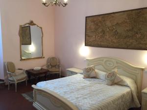 a bedroom with a bed and a mirror and chairs at Casalbergo in Siena
