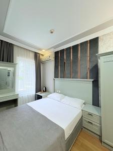 a bedroom with a large white bed and a tv at Grand Hurriyet Hotel in Istanbul