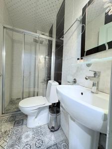 a bathroom with a toilet and a sink and a shower at Grand Hurriyet Hotel in Istanbul