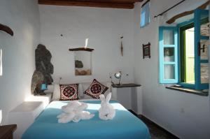 two towels on a bed with two rabbits on it at Pano Gitonia in Aegiali