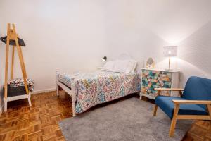 une chambre avec un lit et une chaise bleue dans l'établissement GuestReady - Furnas Nest, à Furnas