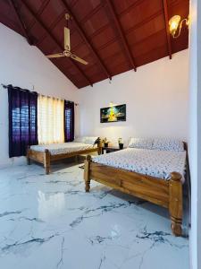 two beds in a room with marble floors at SkyScape Homestay- near to falls ettina bhuja treaking, devaramane, bettadhabiraveshvara in Mudigere