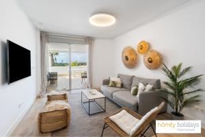 a living room with a couch and a tv at Homity Holidays - Playa Granada - Mar de Astrid in Motril +282 photos