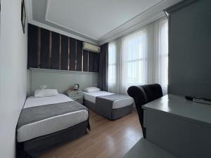 a hotel room with two beds and a desk at Grand Hurriyet Hotel in Istanbul