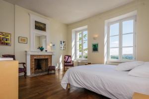 a bedroom with a white bed and a fireplace at Le petit chateau in Vicq-sur-Breuilh +59 photos