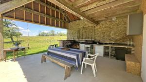 a patio with a table and chairs and a kitchen at Le petit chateau in Vicq-sur-Breuilh