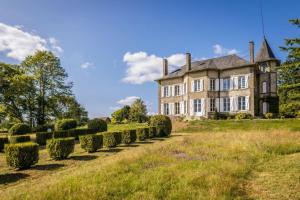 an old house with hedges in front of it at Le petit chateau in Vicq-sur-Breuilh