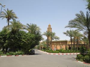 a car parked in front of a building with palm trees at Riad Four Rooms & Pool in Marrakesh