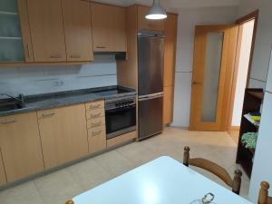 a kitchen with wooden cabinets and stainless steel appliances at Costa Monte Blanco Cabana in Cabana de Bergantiños