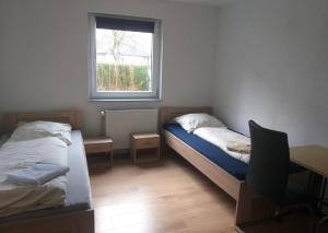 a room with two beds and a desk and a window at Monteurwohnung Göllheim in Göllheim