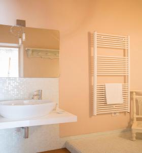 ein Badezimmer mit einem weißen Waschbecken und einem Spiegel in der Unterkunft Villa Sestilia Guest House in Montaione