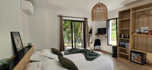 a bedroom with a bed and a large window at Hôtel Résidence de standing Casa Pian d'Olmo in Olmiccia