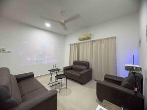 a living room with two couches and a table at 25 pax Golf Resort Private Villa in Kulim