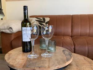 ZwiggelteにあるVelduil I Mooi Huisje met Ruime Tuinのワイン1本とワイングラス2杯(テーブル上) +37枚の写真