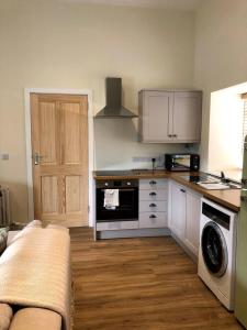 a kitchen with a sink and a stove top oven at Cosy country cottage beside Ancient Woodlands in Paxton