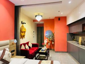 a living room with orange walls and a red couch at Spira Supernova in New Delhi