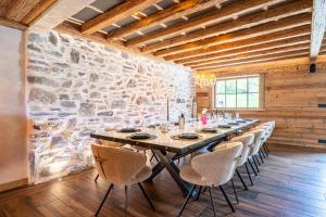 a long table in a room with a stone wall at Chalet Gaston in Champagny-en-Vanoise