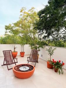 a patio with two chairs and a fire pit at Apê Sunshine| Terraço| Interação com animais in Florianópolis