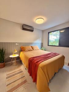 a bedroom with a large bed and a window at Apê Sunshine| Terraço| Interação com animais in Florianópolis