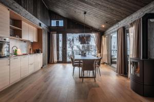 a kitchen with a table and chairs in a room at Kikut Alpin Lodge 1301 in Hol