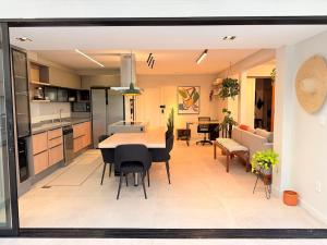 a kitchen and living room with a table and chairs at Apê Sunshine| Terraço| Interação com animais in Florianópolis +22 photos