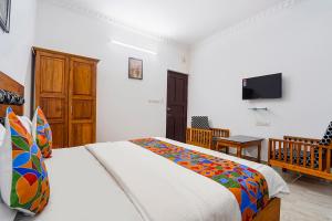 a bedroom with a bed and a flat screen tv at Fabhotel Star Inn Plus - Nr Kovalam Beach in Kovalam +33 photos