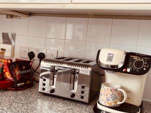 a toaster and coffee maker sitting on a kitchen counter at Lovely 2 bedroom house in Bath with private parking garden WiFi & easy access to city centre in Bath