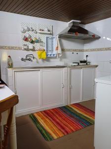 a kitchen with white cabinets and a sink at Casa da Bia in Nisa +8 photos
