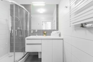 un bagno bianco con lavandino e doccia di APARTAMENTY MIERZEJA - MARINA, Kąty Rybackie, Klimatyzacja,100 m od Zalewu Wiślanego a Kąty Rybackie Altre 33 foto