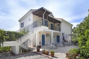 a white house with a staircase and a patio at Panorama studios 3 in Póndi