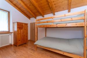 a bedroom with a bunk bed and a wooden ceiling at La Casa di Elvira-Mansarda in Alleghe