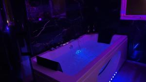a bathroom with a tub with purple lighting at Evasion balneo Fréjus in Fréjus