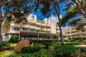 a large white building with trees in front of it at O7 Club Cala Ratjada in Cala Ratjada