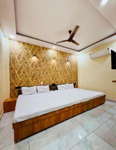 a bedroom with a large bed with a ceiling at Hotel Naagshree in Ujjain