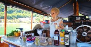 Una mujer parada en una cocina con un mostrador con ingredientes. en Passeio de barco na Escuna Ibiza, en Paraty 15 fotos más