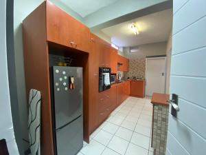 eine Küche mit Holzschränken und einem Edelstahlkühlschrank in der Unterkunft AfricaLove on Tiger Suite in Pretoria
