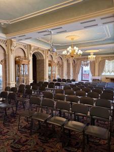 a room with rows of chairs and a chandelier at Axelhof Boutique Hotel in Dnipro