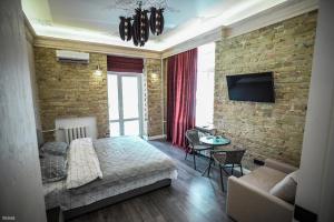 a bedroom with a bed and a brick wall at Olympic studio in Kyiv