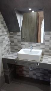 a bathroom with a white sink and a mirror at Cycladic Relaxation Corner in Fira