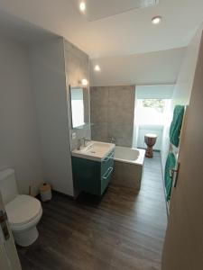 a bathroom with a tub and a toilet and a sink at Chambres proches du circuit des 24 heures du Mans, au calme in Fay