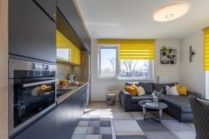 eine Küche und ein Wohnzimmer mit einem Sofa und einem Wohnzimmer in der Unterkunft Sunset Resort 409 With Pool - Happy Rentals in Fonyód