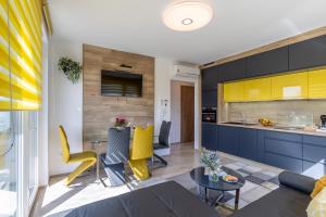 kuchnia i salon z niebieskimi szafkami i żółtymi krzesłami w obiekcie Sunset Resort 409 With Pool - Happy Rentals w mieście Fonyód