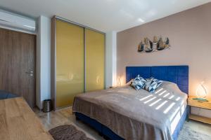 sypialnia z dużym łóżkiem z niebieskim zagłówkiem w obiekcie Sunset Resort 409 With Pool - Happy Rentals w mieście Fonyód