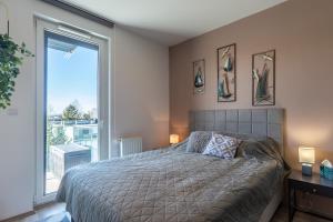 ein Schlafzimmer mit einem Bett und einem großen Fenster in der Unterkunft Sunset Resort 409 With Pool - Happy Rentals in Fonyód + 31 Fotos