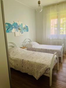 una camera da letto con due letti e una finestra di Le Rose a Trieste